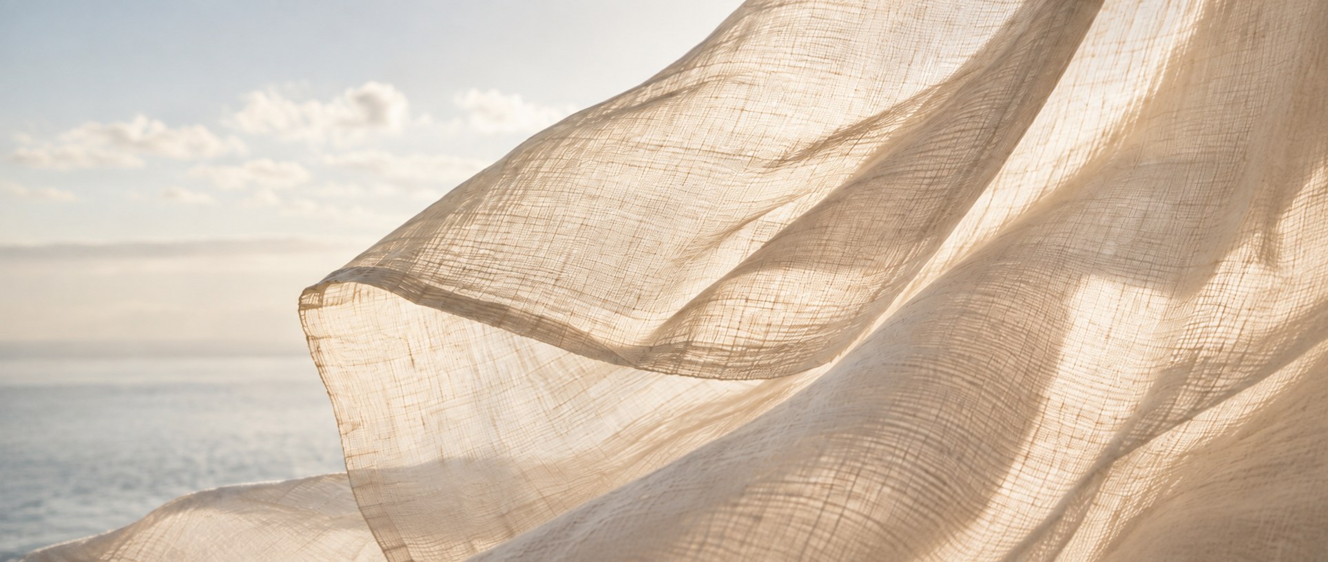 Sunlit linen against a calm sea and open sky.